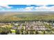 Beautiful aerial view of a community nestled among lush trees next to a large pond, with a view of the city at 1222 Golden Canna Ln, Celebration, FL 34747