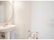 Clean bathroom featuring white pedestal sink, mirror, and paper holder at 1222 Golden Canna Ln, Celebration, FL 34747