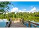 Scenic view of a wooden dock over a tranquil lake surrounded by lush greenery at 1222 Golden Canna Ln, Celebration, FL 34747