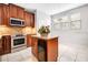 Kitchen featuring wood cabinets, granite counters, stainless steel oven, and island with a wine cooler at 1222 Golden Canna Ln, Celebration, FL 34747