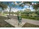Scenic view of a serene lake with a bench and walking path surrounded by lush greenery at 1222 Golden Canna Ln, Celebration, FL 34747