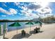 A peaceful lakeside view with green umbrellas, seating and a picturesque building in the background at 1222 Golden Canna Ln, Celebration, FL 34747