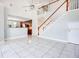 Open-concept living area with tiled flooring and a view of the adjacent kitchen and staircase at 1222 Golden Canna Ln, Celebration, FL 34747