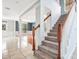 Bright foyer showcasing a staircase with carpeted steps and wooden handrail leading to the second floor at 1222 Golden Canna Ln, Celebration, FL 34747