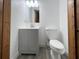 Clean bathroom featuring a gray vanity, toilet, new fixtures, and a wood-look floor at 1288 Se 32Nd St, Ocala, FL 34471