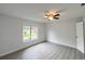 Cozy bedroom with wood-look flooring, neutral walls, ceiling fan, and a view of the front yard at 1288 Se 32Nd St, Ocala, FL 34471