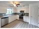 Well-lit kitchen featuring stainless steel appliances, white cabinets, modern countertops, and wood-look flooring at 1288 Se 32Nd St, Ocala, FL 34471