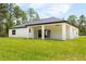 Beautiful backyard featuring a covered patio, lush lawn, and well-maintained landscaping at 13619 Sw 78Th Place, Dunnellon, FL 34432