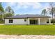 Well-maintained backyard with a covered patio, a lush green lawn, and ample space for outdoor activities at 13619 Sw 78Th Place, Dunnellon, FL 34432