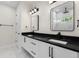 Bathroom featuring a double vanity with black marble countertops and two mirrors at 13619 Sw 78Th Place, Dunnellon, FL 34432