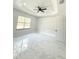 Bright bedroom with tile floors, a ceiling fan, and a large window offering ample natural light at 13619 Sw 78Th Place, Dunnellon, FL 34432