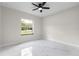 Bright bedroom features a ceiling fan, and a large window for natural light, complemented by marble floors at 13619 Sw 78Th Place, Dunnellon, FL 34432