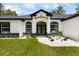 Inviting front entrance features a double-door entry and decorative stone accents, complemented by green grass at 13619 Sw 78Th Place, Dunnellon, FL 34432