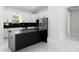 Bright kitchen with a black island, stainless steel refrigerator, white cabinets, and sleek marble countertops at 13619 Sw 78Th Place, Dunnellon, FL 34432
