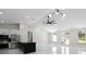 Open-concept living space with a black kitchen island, ceiling fan, stainless steel appliances, and modern lighting at 13619 Sw 78Th Place, Dunnellon, FL 34432