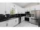 Modern kitchen with stainless steel appliances, a black marble backsplash, and white cabinets at 13619 Sw 78Th Place, Dunnellon, FL 34432