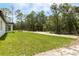 A spacious yard with lush green grass extends from the house towards a border of mature trees at 13619 Sw 78Th Place, Dunnellon, FL 34432