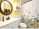 Well-lit bathroom with floral shower curtain and decorative mirror at 1462 Mt Laurel Dr, Winter Springs, FL 32708