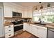 Efficient kitchen showcasing stainless steel appliances, white cabinetry, and dark countertops at 1462 Mt Laurel Dr, Winter Springs, FL 32708