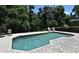 Inviting in-ground swimming pool surrounded by a spacious brick patio and lush, mature trees at 1462 Mt Laurel Dr, Winter Springs, FL 32708