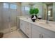 Modern bathroom with double vanity, quartz countertops, a glass-enclosed shower, and elegant fixtures at 152 Fredericksburg Ave, Orange City, FL 32763