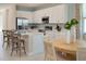 Bright kitchen featuring white cabinets, stainless steel appliances, an island, and an adjacent dining area at 152 Fredericksburg Ave, Orange City, FL 32763