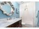 Bathroom features charming blue walls, a shower over tub, and marble countertop vanity at 1600 N Wind Ct, Winter Springs, FL 32708