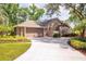 Well-maintained home exterior featuring a spacious driveway, lush landscaping, and an attached garage at 1600 N Wind Ct, Winter Springs, FL 32708