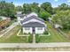 Aerial view of the home showing the neatly landscaped yard, mature trees, and inviting front porch at 161 Bolender Rd, Auburndale, FL 33823