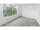Cozy bedroom featuring soft neutral carpet, crisp white walls, and a large window with neighborhood views at 161 Bolender Rd, Auburndale, FL 33823