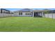 Expansive backyard featuring an oversized lawn, solar panels, and a screened-in patio at 1821 Benevento St, St Cloud, FL 34771