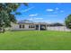 Green backyard with solar panels on roof, and a screened-in lanai at 1821 Benevento St, St Cloud, FL 34771
