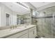 Elegant bathroom featuring double sinks, framed mirror, shower with glass door, and neutral tile at 1821 Benevento St, St Cloud, FL 34771