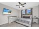 Bright bedroom with a ceiling fan, dresser, television, and a comfortable bed with decorative pillows at 1821 Benevento St, St Cloud, FL 34771