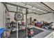 Garage converted into a home gym with weightlifting equipment, exercise bike, and rubber flooring at 1821 Benevento St, St Cloud, FL 34771