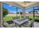Screened lanai with dining table, chairs, and ceiling fan overlooking the green backyard at 1821 Benevento St, St Cloud, FL 34771