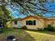 Single-story home with an inviting backyard featuring a fire pit and partially shaded grassy area at 2 Clear Pl, Ocala, FL 34472