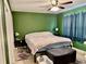 Comfortable bedroom with a ceiling fan, a patterned bedspread, and neutral tile flooring at 2 Clear Pl, Ocala, FL 34472