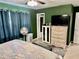 Bedroom featuring green walls, with dark curtains, neutral tile flooring, and a ceiling fan at 2 Clear Pl, Ocala, FL 34472