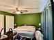 Bedroom with a ceiling fan, green walls, window with curtain, and furnishings at 2 Clear Pl, Ocala, FL 34472