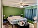 Bedroom featuring a ceiling fan, green walls, and a window with curtains at 2 Clear Pl, Ocala, FL 34472