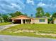 Charming single-story home with a covered carport and solar panels, set against a partly cloudy sky at 2 Clear Pl, Ocala, FL 34472
