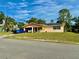 A quaint, single-story home featuring an open carport, solar panels, and neatly kept lawn at 2 Clear Pl, Ocala, FL 34472