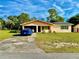 Charming single-story home featuring an open carport, solar panels, and a well-maintained front lawn at 2 Clear Pl, Ocala, FL 34472