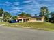 A quaint, single-story home featuring an open carport, solar panels, and neatly kept lawn at 2 Clear Pl, Ocala, FL 34472