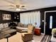 Cozy living room with a large sectional sofa, ceiling fan, and a black accent wall at 2 Clear Pl, Ocala, FL 34472