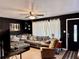 Stylish living room features a sectional sofa, a black accent wall, and neutral tile flooring at 2 Clear Pl, Ocala, FL 34472