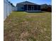 Large backyard featuring a white fence and well-maintained lawn and partially covered lanai at 2049 Crosscreek Ct, Oviedo, FL 32766