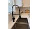 Close-up of the stainless-steel kitchen sink with a sleek black faucet and tiled backsplash at 2049 Crosscreek Ct, Oviedo, FL 32766