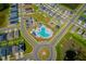 Community aerial view showcasing a pool, playground, parking, and modern homes with sidewalks and landscaping at 214 Brave Rd, Davenport, FL 33837